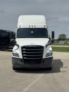 Front view of a white Freightliner Cascadia 126 semi truck with large black grille and bumper, in-service condition.