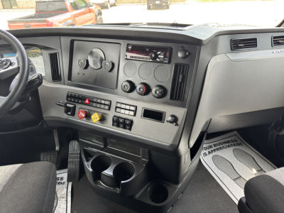 Truck dash of a Freightliner Cascadia sleeper showing instrument cluster, controls, and cup holders.