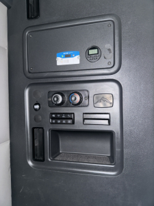 Freightliner Cascadia interior panel showing control cluster and dashboard panel with digital gauge and auxiliary compartments.