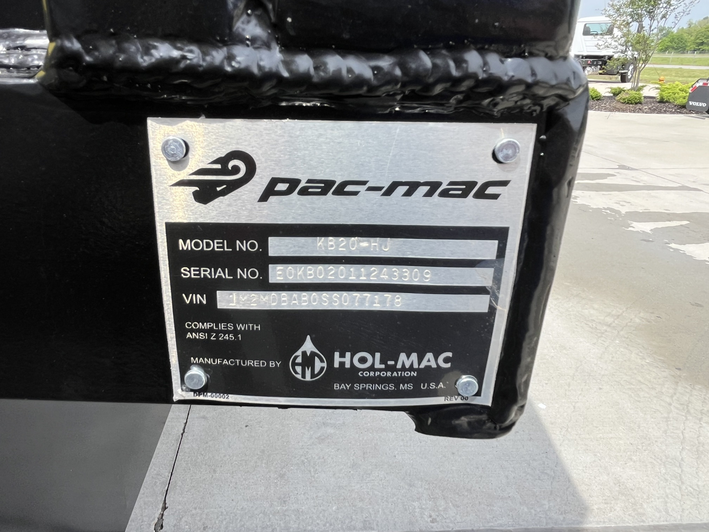 Label plate on Mack truck component showing Pac-Mac Hol-Mac logo, model no. KB20-HJ, serial no. E0KB0201243309, VIN 1M2MDBAB3SS077353, manufactured by Hol-Mac Corporation.