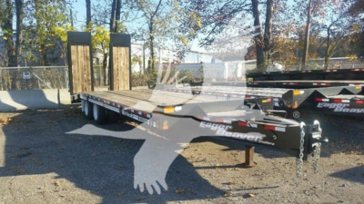 Trailer deck of a flatbed trailer showing dual axles and ramp platforms with 'Eager Beaver' branding readable along the frame.
