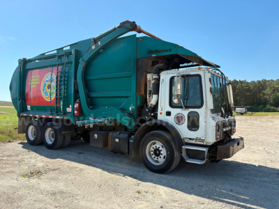 Garbage truck 2012 Mack MRU613 in-service showing garbage body and dumping mechanism.