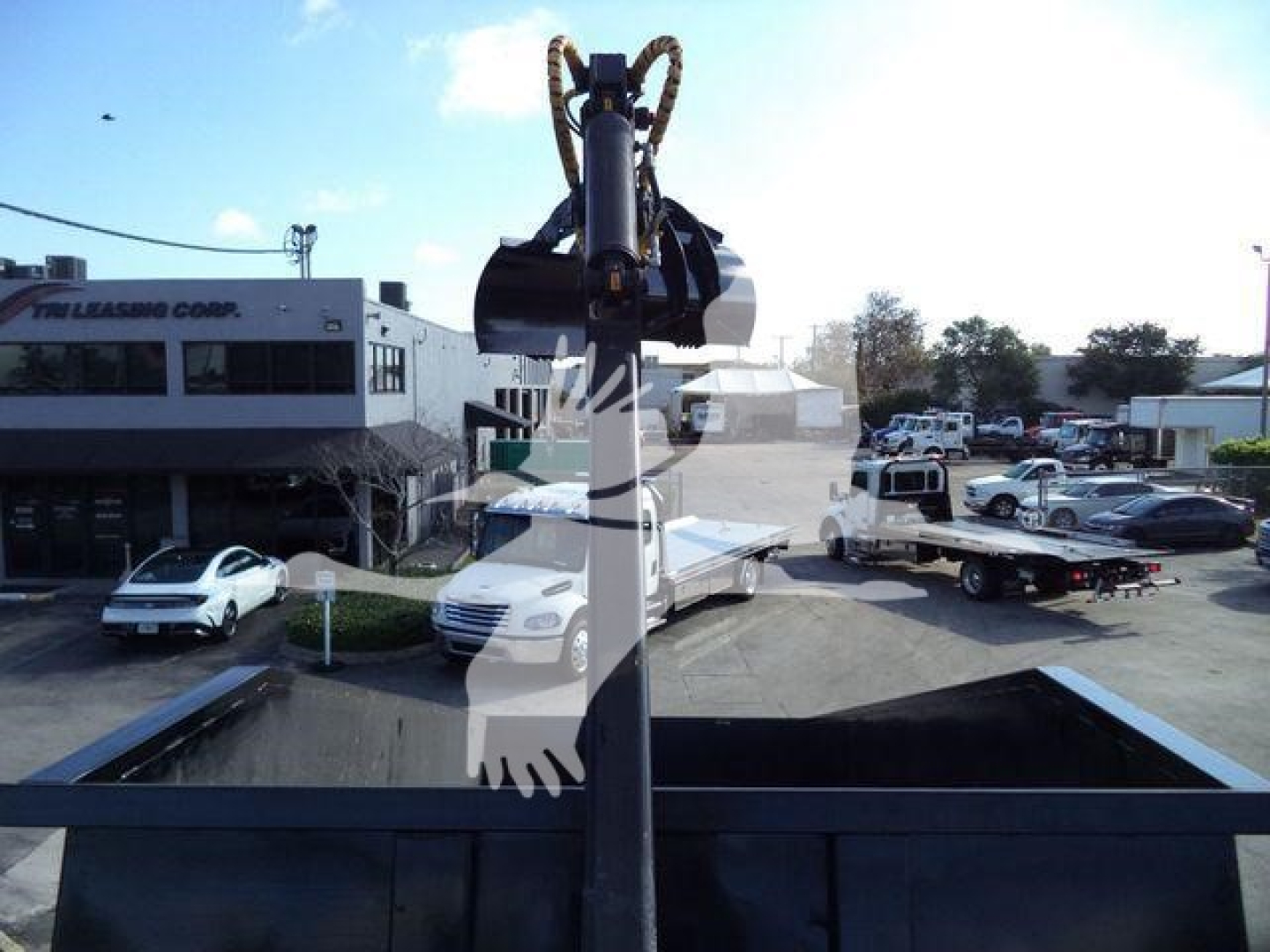 Front view of a 2023 Chevrolet Silverado 6500HD in a dealership lot with a head-on crane attachment visible in foreground