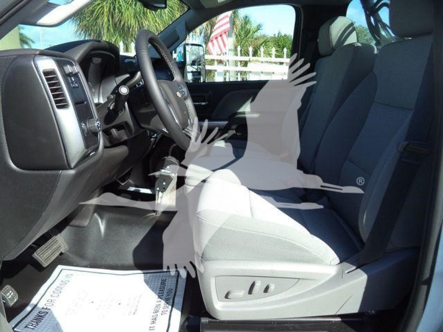 Interior view of a 2023 Chevrolet Silverado 6500HD cab with front seats and dashboard; steering wheel visible.