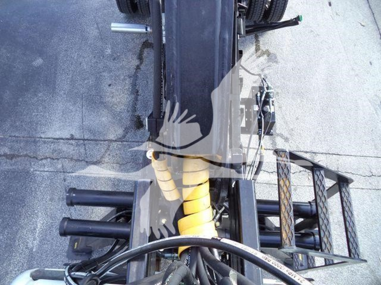 Truck chassis and suspension components of a 2023 Chevrolet Silverado 6500HD seen from above, with yellow coil suspension and black tubular frame.