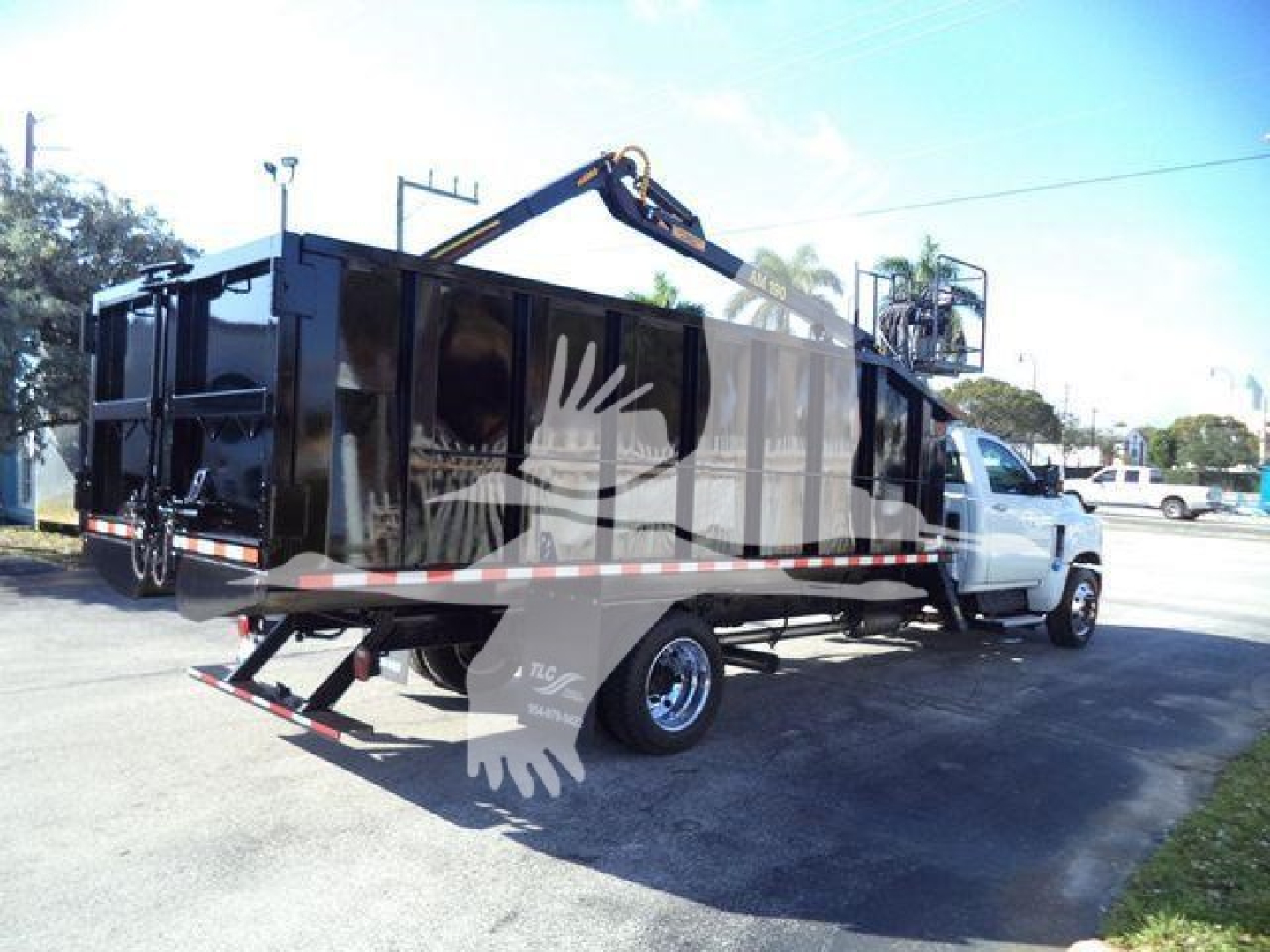 Chevrolet Silverado 6500HD dump truck in-service showing rear loading ramp and hydraulic crane attachment