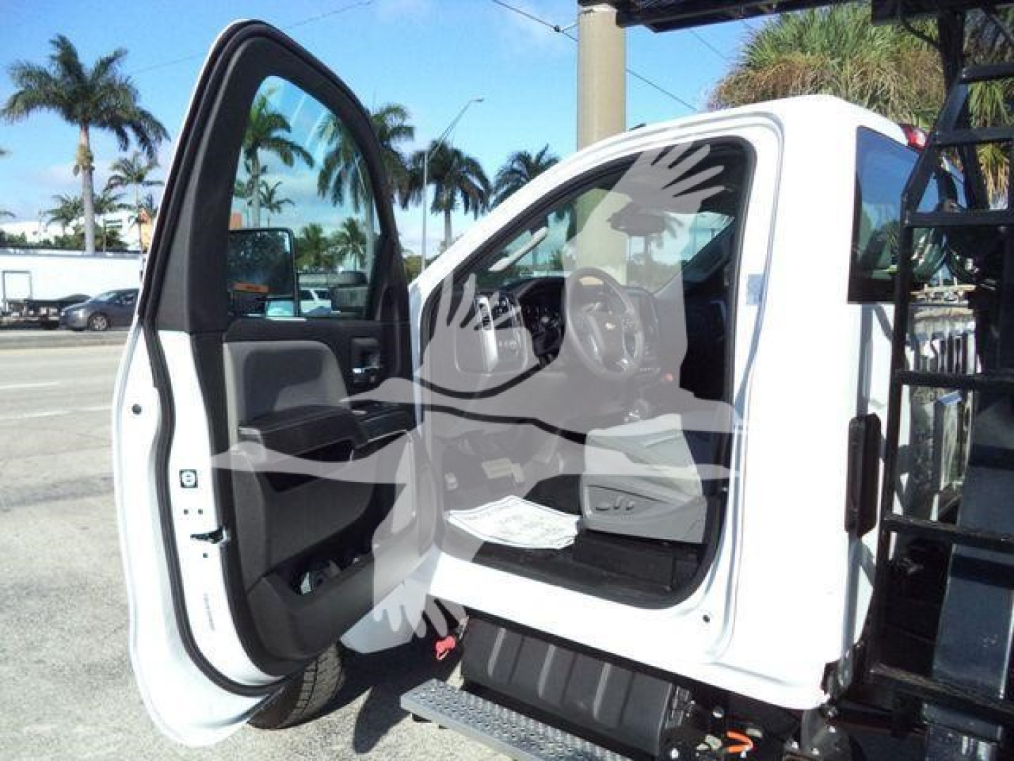 Truck cab interior with front passenger door open, showing Chevrolet Silverado 6500HD interior and entry step.