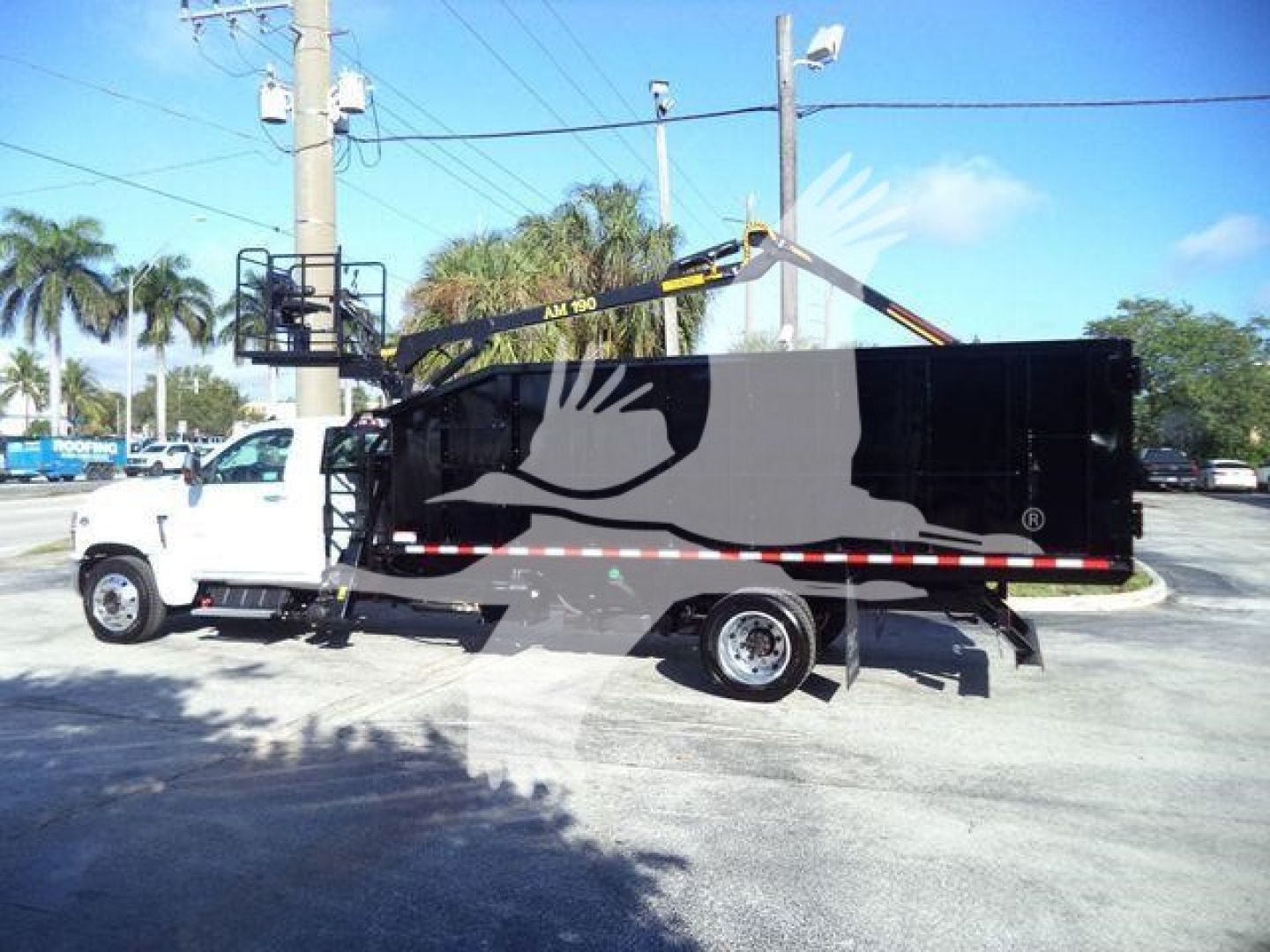 Truck-mounted refuse body with a hydraulic arm/boom on a Chevrolet Silverado 6500HD chassis; side view showing black refuse body and white cab.