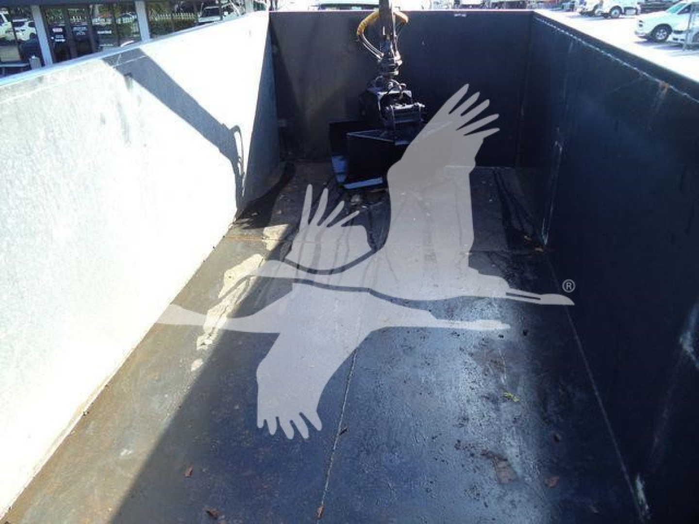 Truck bed of a 2023 Chevrolet Silverado 6500HD showing empty cargo area with hitch and hydraulic hook, no visible text.