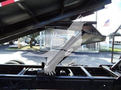 Close-up of a Chevrolet Silverado 6500HD truck chassis showing a hydraulic lift arm with a label. Visible text includes 'GVWR' and branding on the arm.