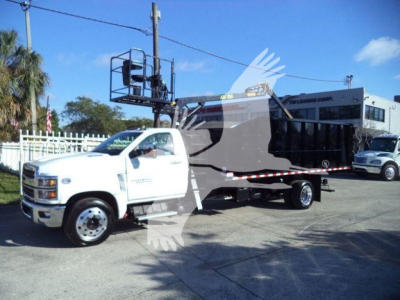 Chevrolet Silverado 6500HD truck with bucket lift mounted on a flatbed, white cab, in a dealership lot.