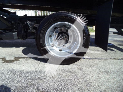 Chevrolet Silverado 6500HD front wheel and suspension visible under truck, silver steel wheel and tire.