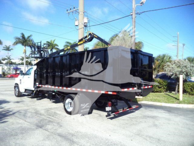 Truck bed with dump-style cargo container on a white Chevrolet chassis, side view showing hydraulic lift and rear hitch.