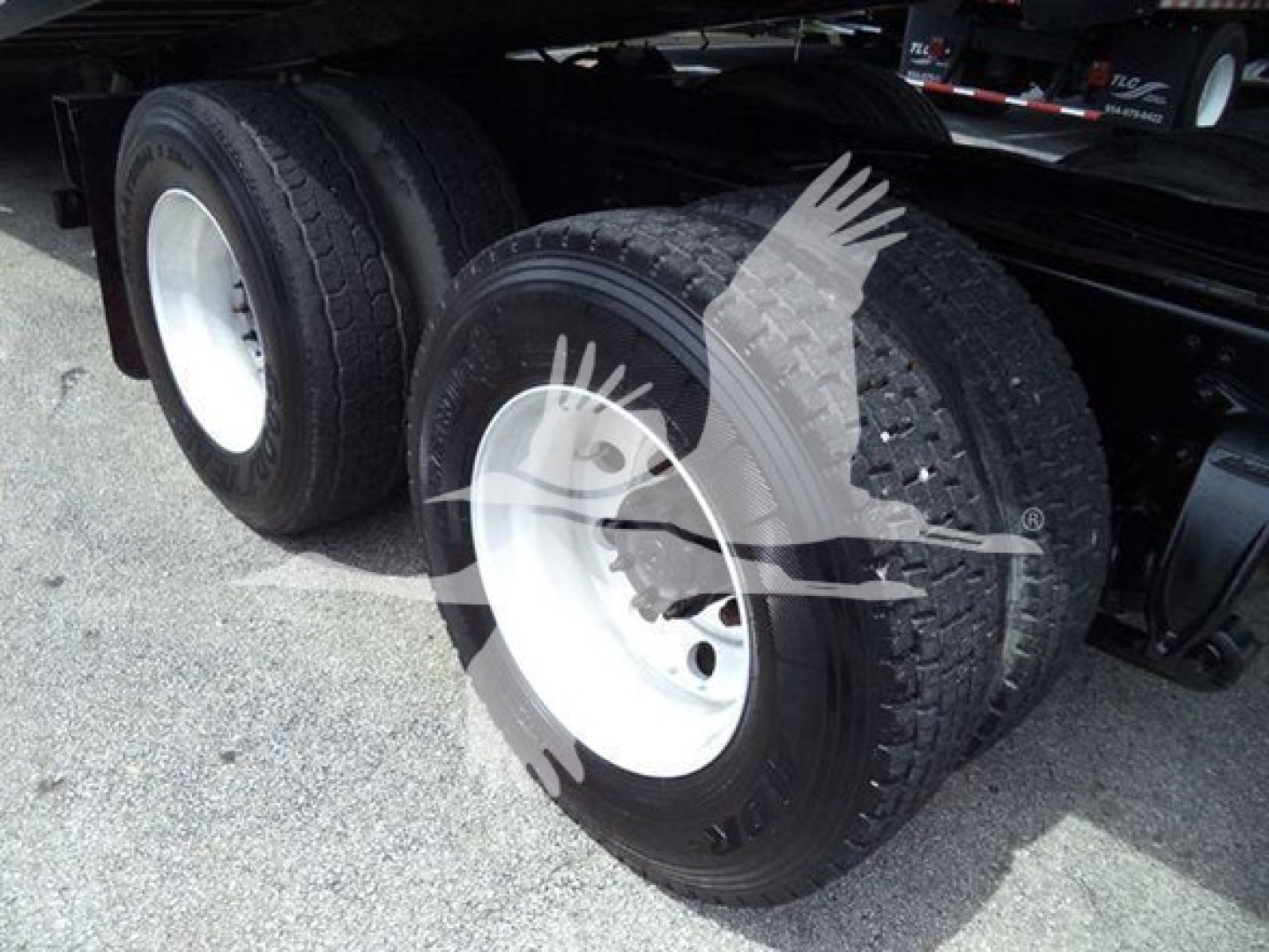 Dual rear axles on a Freightliner Business Class M2 106 truck with white steel wheels and heavy-duty tires.