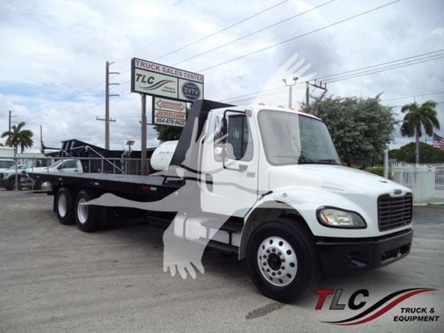 Freightliner Business Class M2 106 rollback truck in white, side view showing cab and flatbed with dual rear axles.