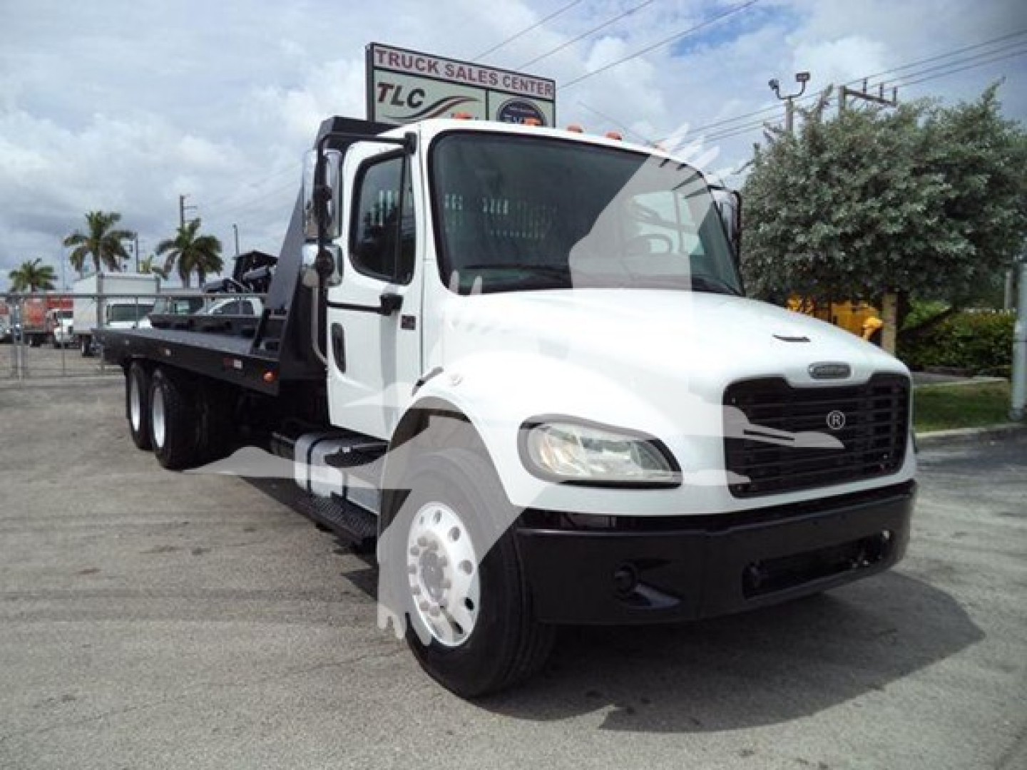 1996 Freightliner Business Class M2 106 rollback truck in white with flatbed, front view showing grille and headlights.