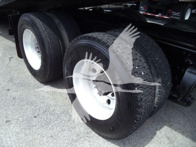 Dual rear axles on a Freightliner Business Class M2 106 truck with white steel wheels and heavy-duty tires.