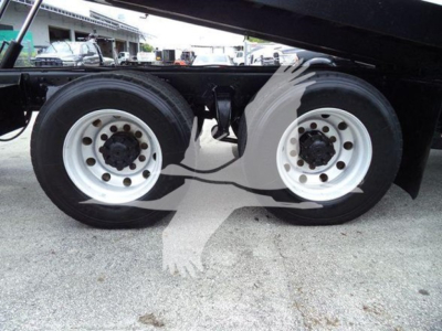 Freightliner Business Class M2 106 rear wheels showing dual white steel rims and tires under a rollback truck.