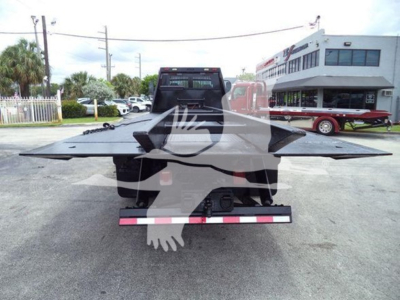 Rear view of a 2006 Freightliner Business Class M2 106 rollback with a heavy-duty tow bed and hitch, visible in a dealership lot.