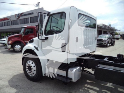 Truck cab of a 2006 Freightliner Business Class M2 106 with white cab, side mirror, and chassis visible; dealership lot in background.