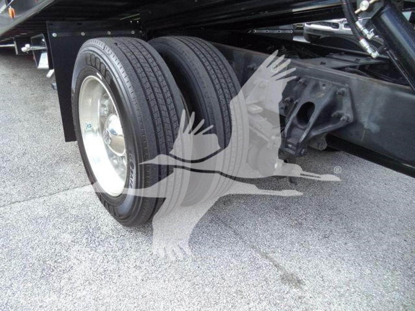 Rear dual wheeled axle of a 2019 Peterbilt 337 rollback truck showing dual tires and frame components.