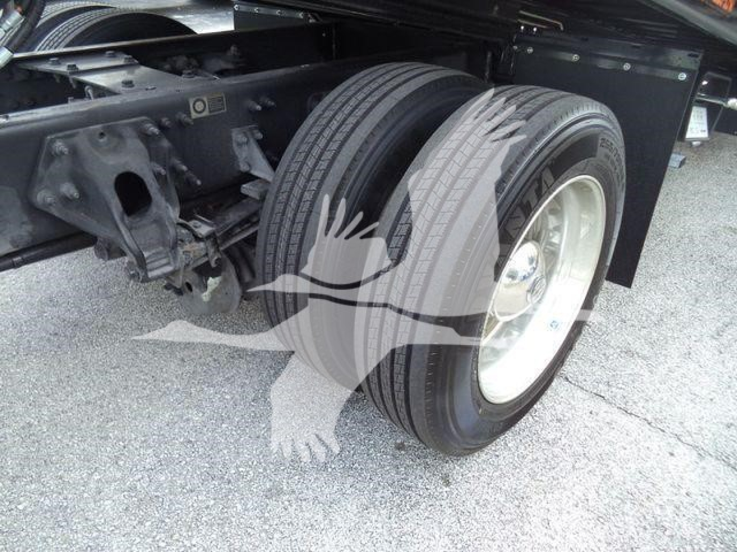 Truck rear wheels and suspension portion of a 2019 Peterbilt 337 rollback truck showing dual rear tires and wheel hub.