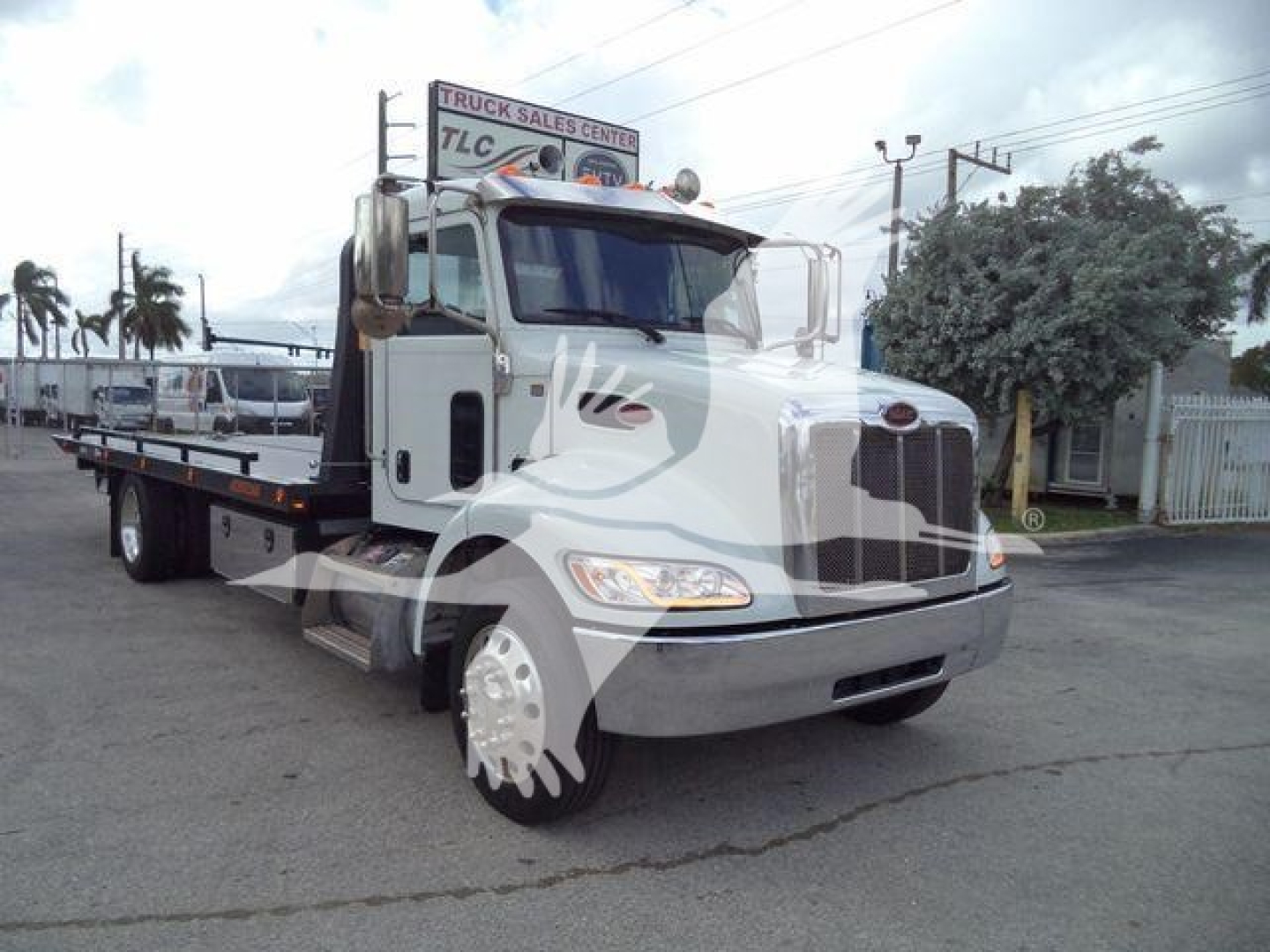 Peterbilt 337 rollback truck in white condition showing front and side with flatbed.