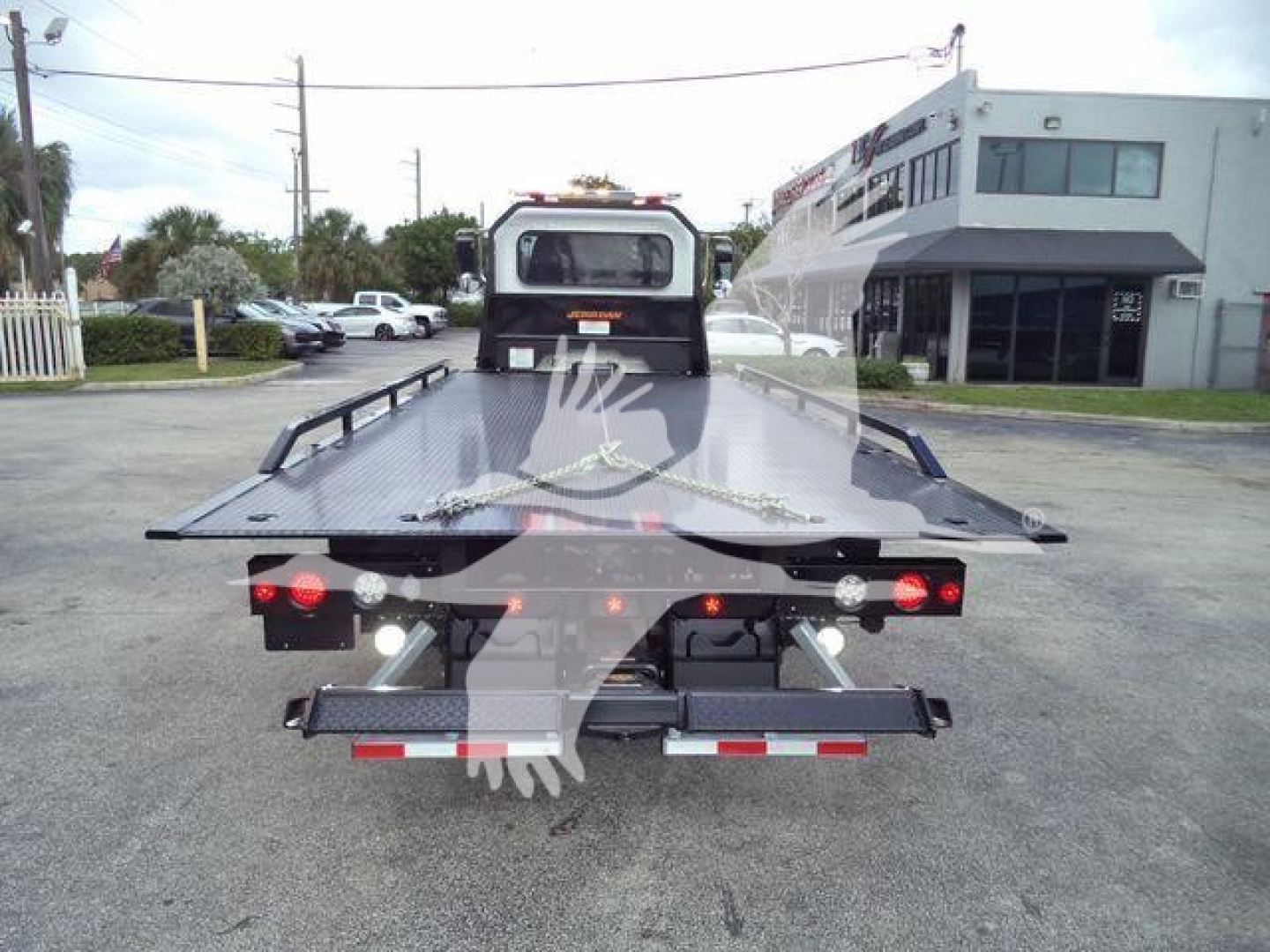 Peterbilt 337 rollback tow truck flatbed rear view showing hydraulic bed with warning lights and ramps.