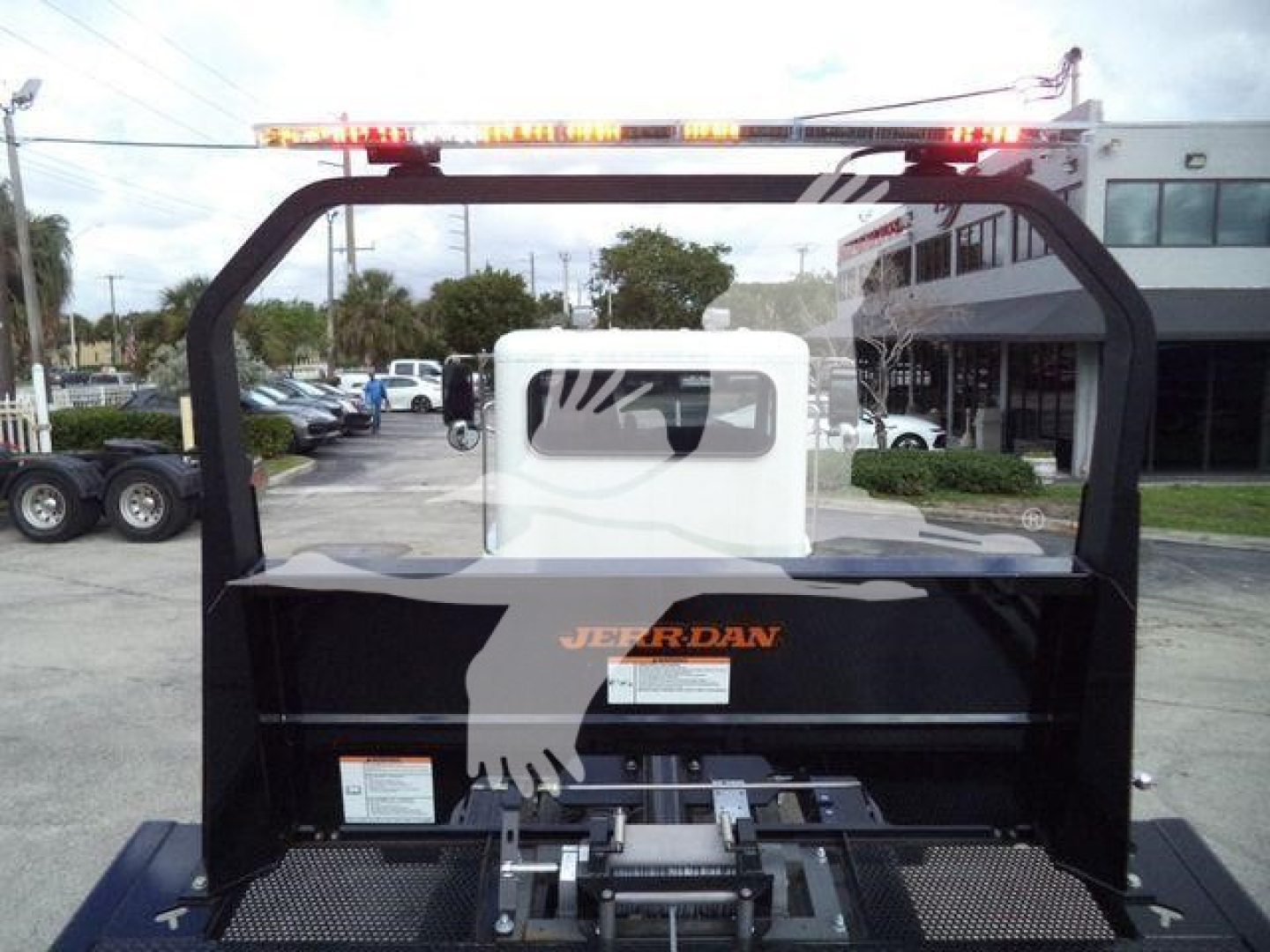 Peterbilt 337 rollback truck bed with black frame and red/amber warning lights on top; visible branding on tailgate area.