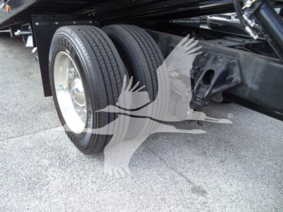 Rear dual wheeled axle of a 2019 Peterbilt 337 rollback truck showing dual tires and frame components.