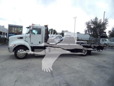 2019 Peterbilt 337 rollback tow truck in side view with flatbed. Visible text: none clearly legible on panels; appears to be a white Peterbilt cab and black flatbed chassis.