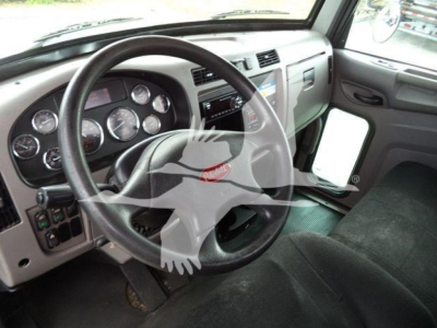Peterbilt 337 truck cab interior showing steering wheel gauges and dashboard through the driver door