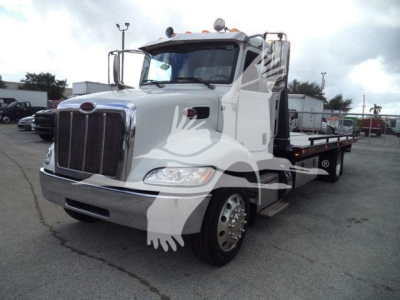 Peterbilt 337 rollback truck in white with chrome grille and flatbed, front three-quarter view.