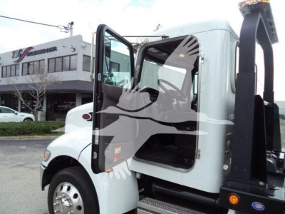 Peterbilt 337 rollback truck cab open with door ajar showing interior and hydraulic boom.