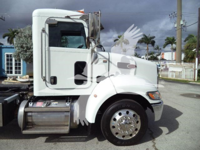 Peterbilt 337 rollback truck side view showing cab, chrome fuel tanks, and front wheel with polished rim.
