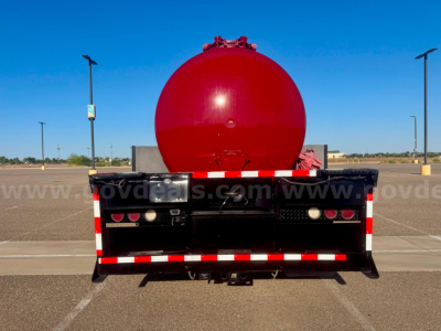 Rear view of a red 2007 Hino vacuum tanker truck with round tank and black chassis, safety lights, and rear bumper Reflective striping.