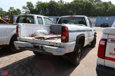 Chevrolet Silverado 2500HD pickup truck rear view with flatbed in a used lot.