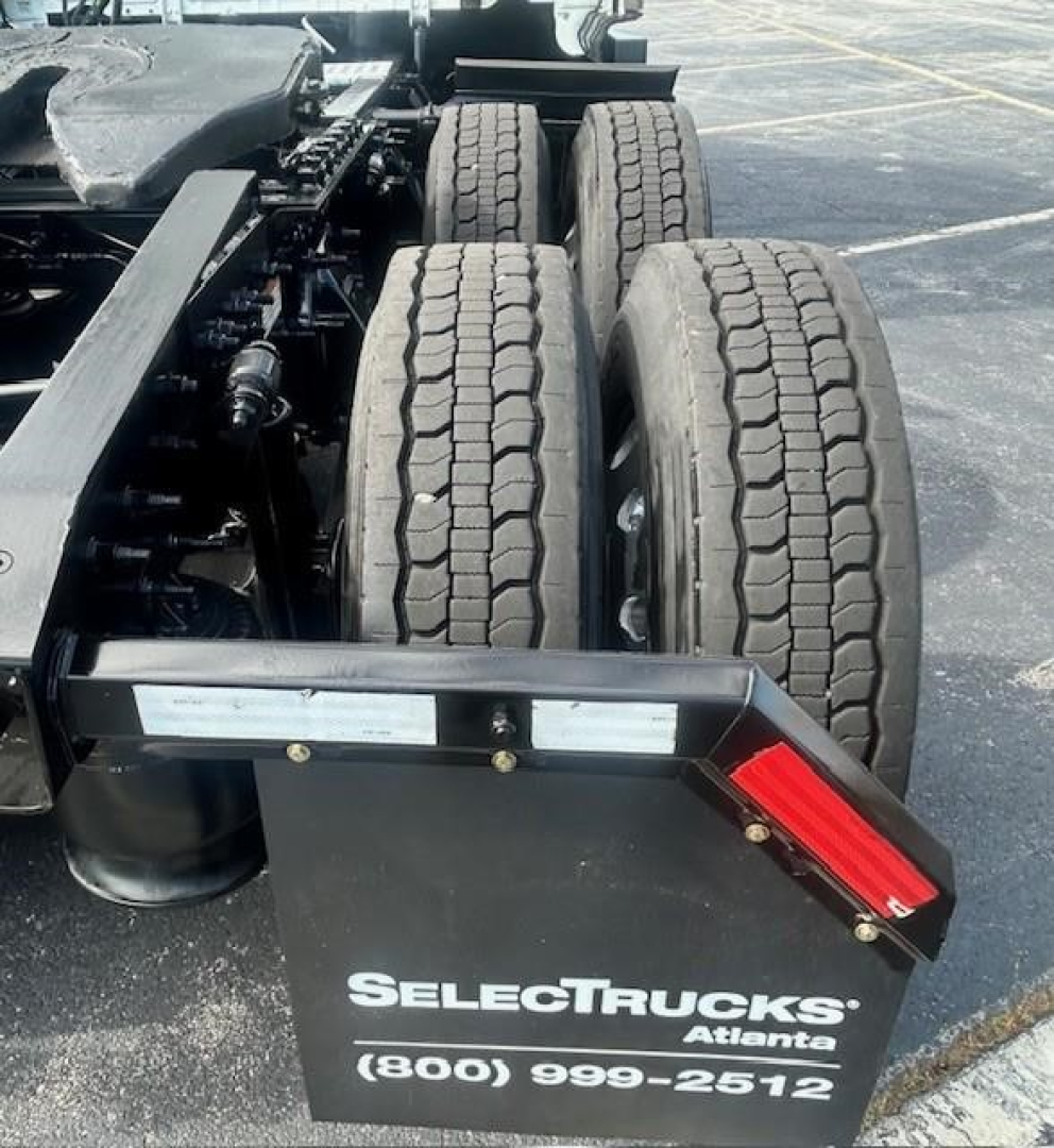 Freightliner Cascadia 116 rear chassis with dual rear axles and mudguard showing SelectTrucks Atlanta plate and contact number.