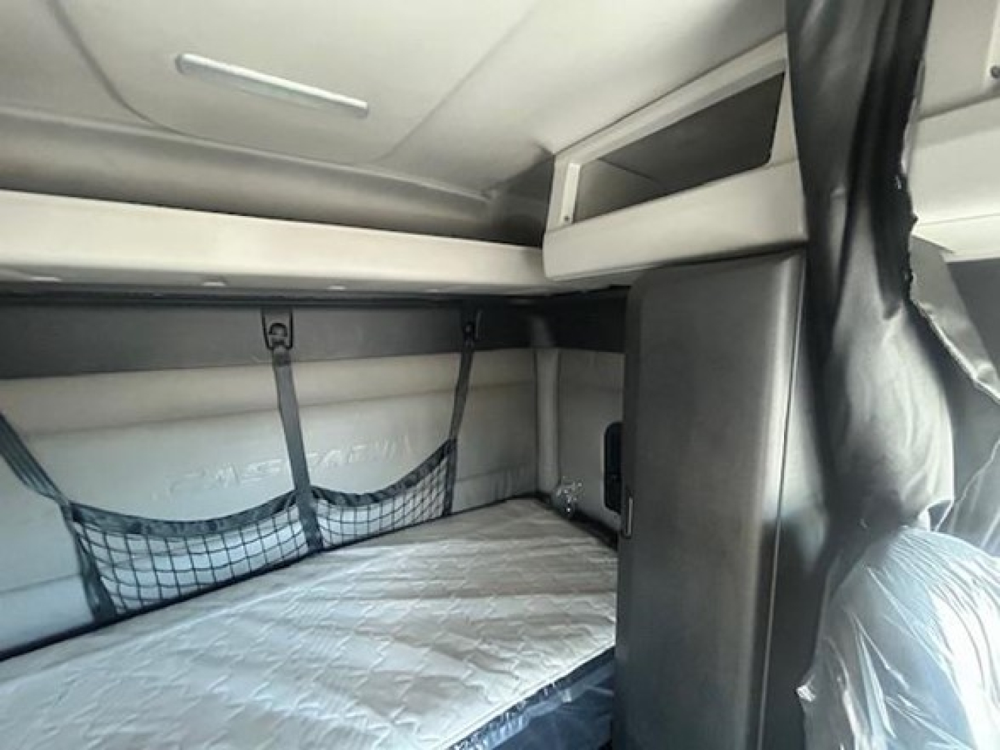 Freightliner Cascadia 116 sleeper cab interior showing sleeper bunk area with net storage and overhead compartments.