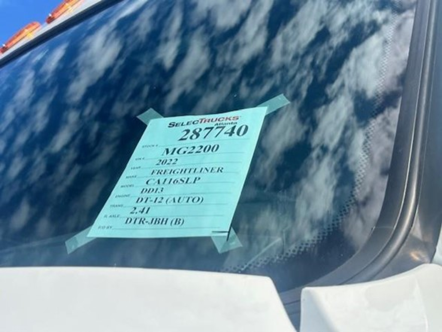 Truck windshield with green listing sticker: 2022 Freightliner Cascadia, 3AKJHPDV0NSMG2200, MTG2200, DR R-12, DL-12 (AUTO), 2-41, DIR-9BH(B)