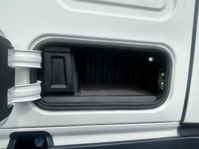 Truck cab door storage compartment with open fuel or DEF filler area? No, this image shows a small under-cab storage pocket recessed into the sleeper cab area of a Freightliner Cascadia.