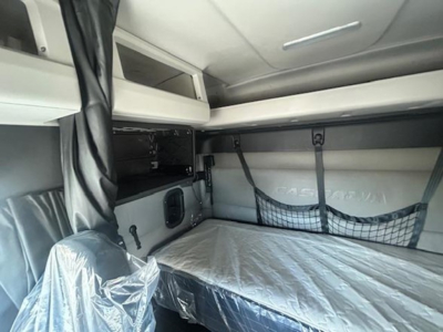  sleeper cab interior showing bunk bed with net storage and overhead shelf in a Freightliner Cascadia cab