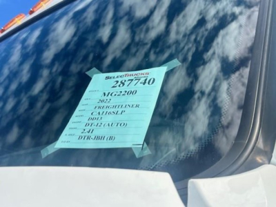 Truck windshield with green listing sticker: 2022 Freightliner Cascadia, 3AKJHPDV0NSMG2200, MTG2200, DR R-12, DL-12 (AUTO), 2-41, DIR-9BH(B)