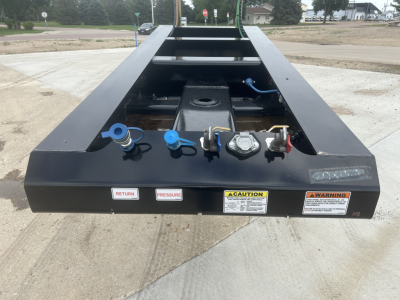 Load King HD702G trailer tongue with blue and red latches, markings for return pressure, warning labels, and hydraulic components visible.