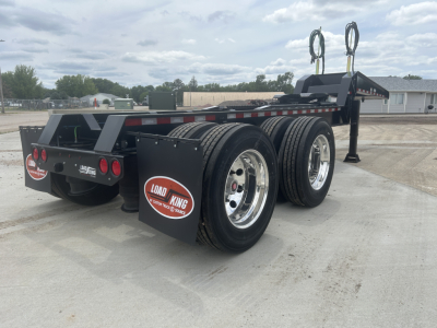 Load King HD702G trailer chassis with dual axles and rear wheel fenders. Visible text includes LOAD KING on mudflaps and rear bumper, and circular labels.