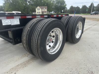 HD702G Load King trailer tandem axle wheels and tires viewed from side showing dual axles and chrome rims.