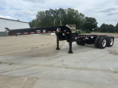 Load King HD702G trailer in a dolly setup showing extended black steel frame, tandem axles, and landing gear.