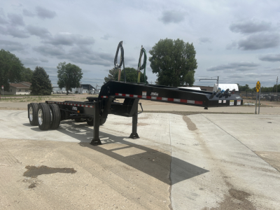 Load King HD702G trailer/dolly with extended gooseneck and dual axles, black frame, in-service with stabilizing legs deployed.