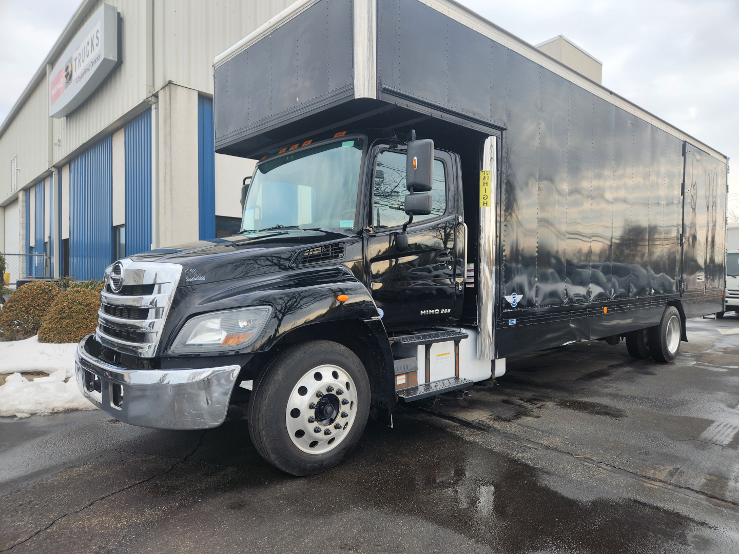 Black 2020 Hino 268A moving van truck side view showing cab and large box cargo area.