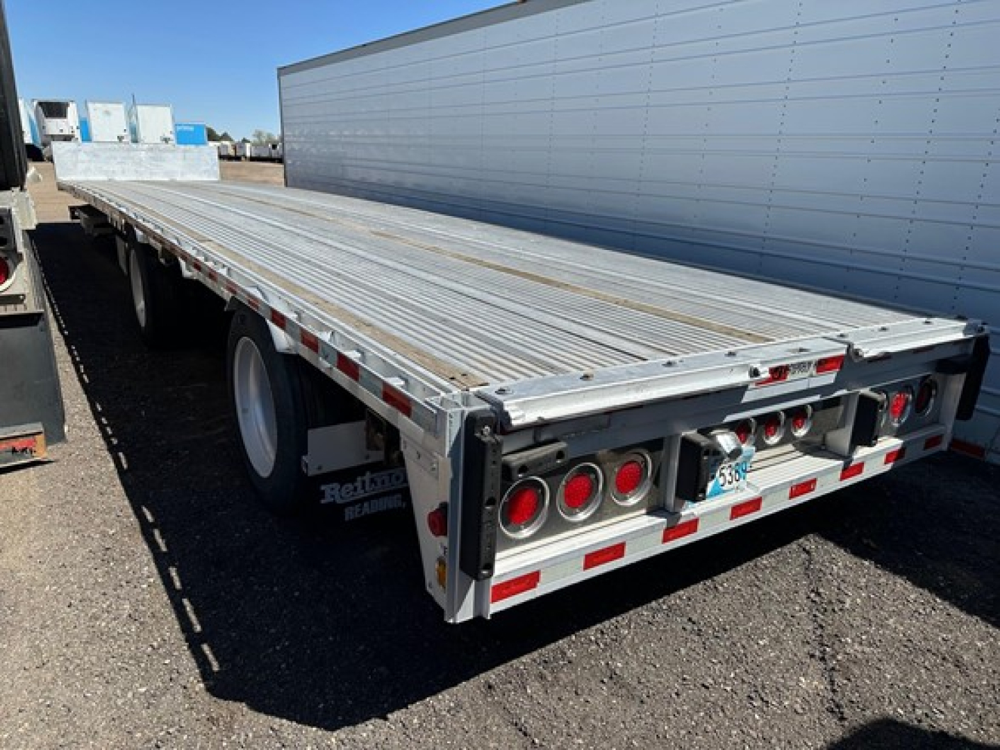 Rear of 2018 Reitnouer all aluminum drop deck trailer showing dual rear axles, aluminum deck, and rear lights; VIN plate and stock area not visible.